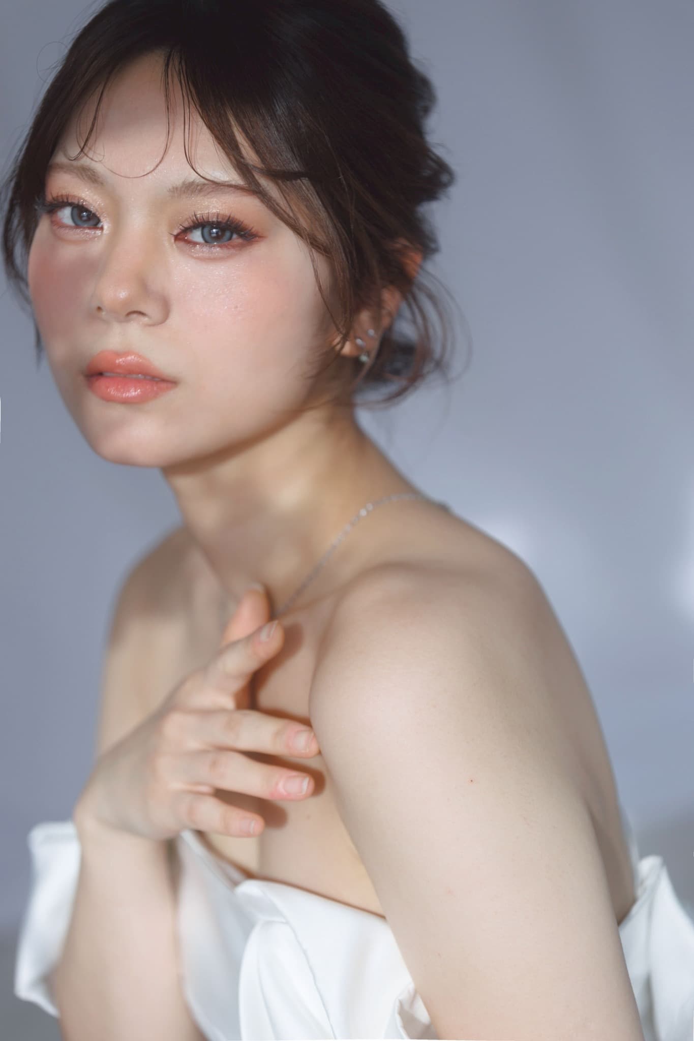 Bridal portrait with a soft updo, softly defined makeup and an off-shoulder white gown